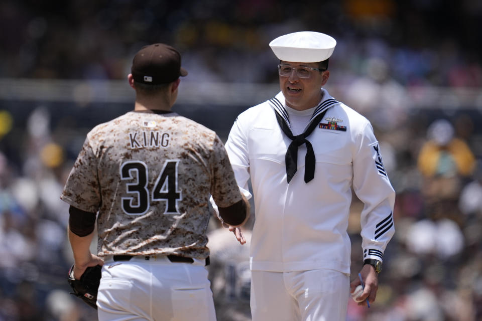 San Diego Padres starting pitcher Michael King, right, greets a sailor before the start of a baseball game against the Milwaukee Brewers, Sunday, June 23, 2024, in San Diego. (AP Photo/Gregory Bull)