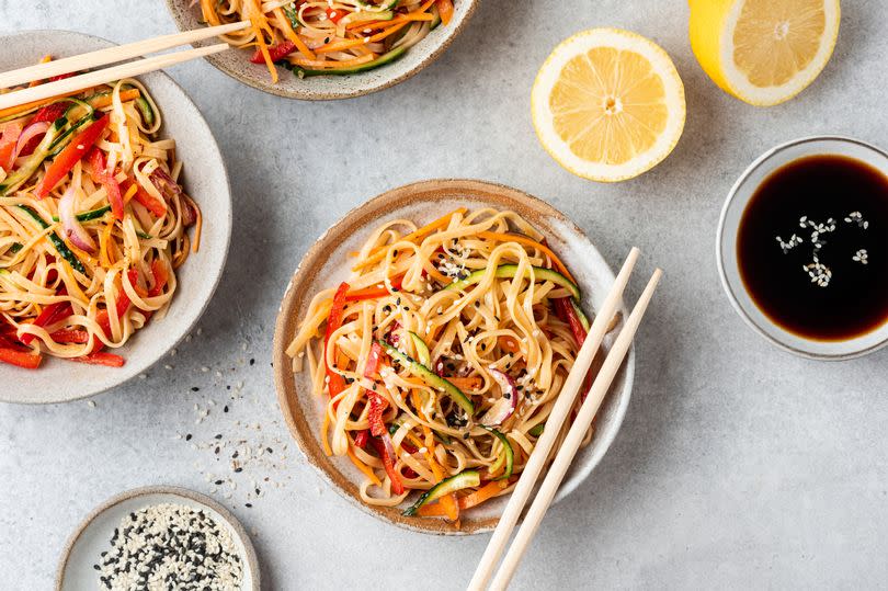 Stir fry rice noodles with vegetables in bowl, top view. Asian cuisine.