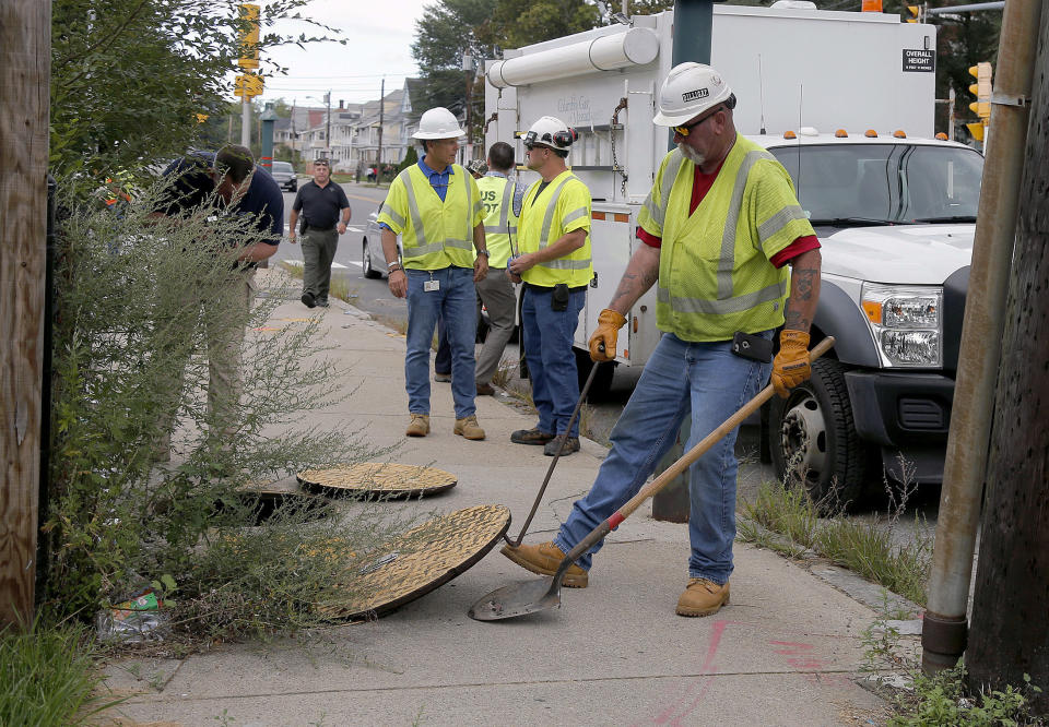 A worker with Columbia Gas pries the manhole cover open as they work to make sure there are no gas leaks at the corner of Parker and Salem Streets in Lawrence, Mass., Friday, Sept. 14, 2018. Multiple houses were damaged Thursday afternoon from gas explosions and fires triggered by a problem with a gas line that feeds homes in several communities north of Boston. (AP Photo/(AP Photo/Mary Schwalm)