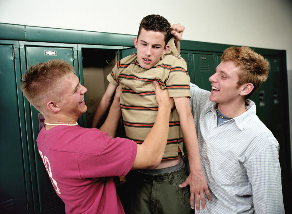 Two bigger guys bullying a smaller guy