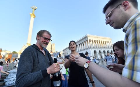 Ukrainian Journalists, who originally rallied at Independence Square in Kiev to mourn anti-Kremlin journalist Arkady Babchenko, celebrate after he appeared alive and well  - Credit: AFP