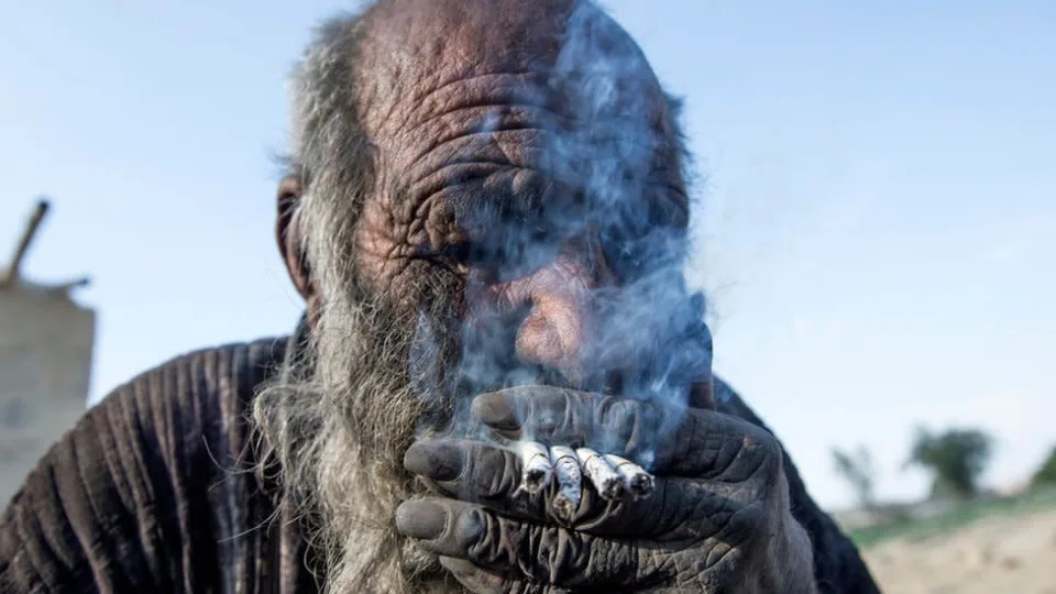 Amou Haji (tio Haji) fotografado fumando quatro cigarros ao mesmo tempo nos arredores da vila de Dezhgah, no distrito de Dehram, no sudoeste da província iraniana de Fars, em 28 de dezembro de 2018