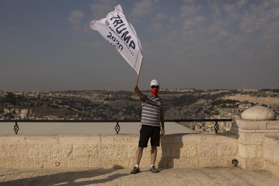 An Israeli supporter of U.S. President Donald Trump waves a campaign flag at a rally for his re-election, on a promenade overlooking Jerusalem, Tuesday, Oct. 27, 2020. (AP Photo/Maya Alleruzzo)