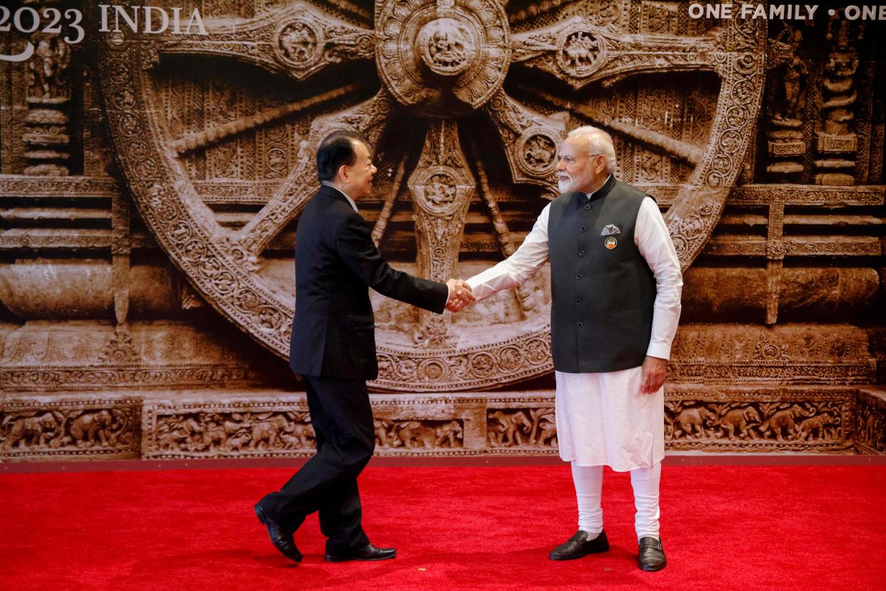 India's Prime Minister Narendra Modi (R) shakes hand with Chinese Foreign Minister Wang Yi at the Bharat Mandapam (POOL/AFP via Getty Images)