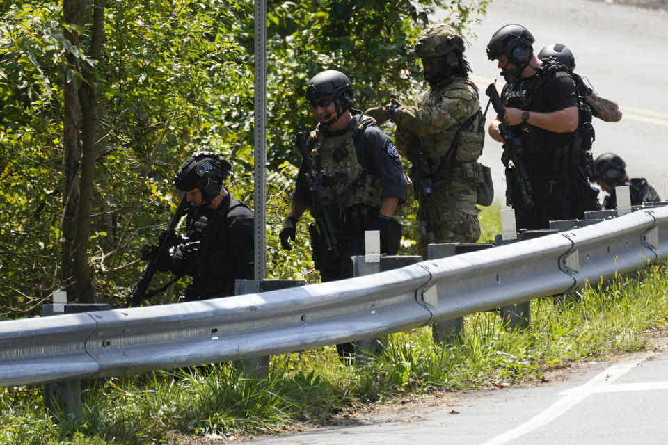 Law enforcement officers enter the woods in the search for the escaped convict on Tuesday.