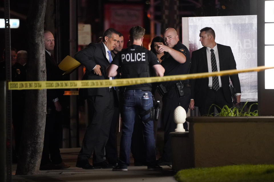 Investigators gather outside an office building where a shooting occurred in Orange, Calif., Wednesday, March 31, 2021. The shooting killed several people, including a child, and injured another person before police shot and wounded the suspect, police said. (AP Photo/Jae C. Hong)