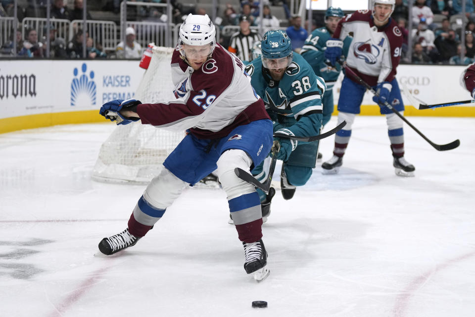 Colorado Avalanche center Nathan MacKinnon (29) and San Jose Sharks defenseman Mario Ferraro (38) vie for the puck during the second period of an NHL hockey game Tuesday, April 4, 2023, in San Jose, Calif. (AP Photo/Tony Avelar)