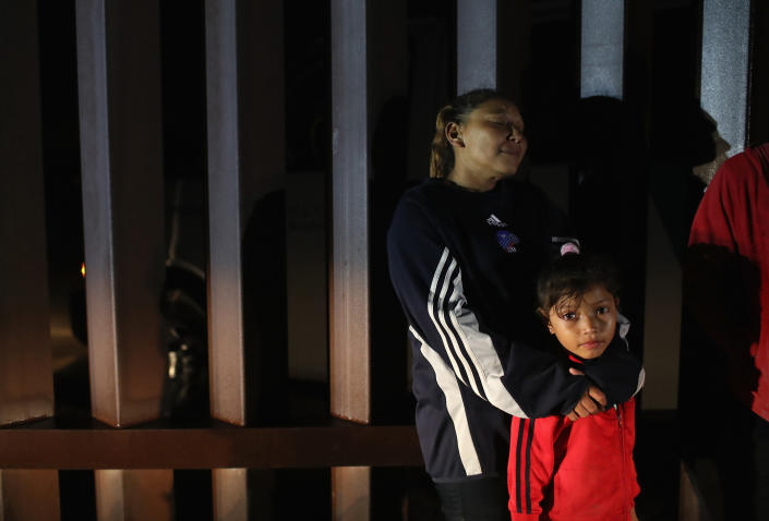 A Honduran mother stands with her family at the U.S.-Mexico border fence on Feb. 22, 2018, near Penitas, Texas.