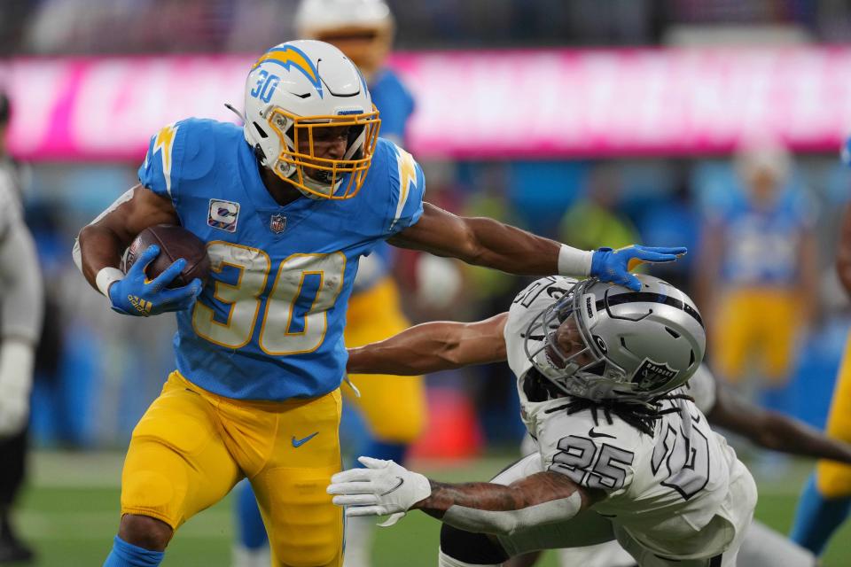 Los Angeles Chargers running back Austin Ekeler (30) stiff arms Las Vegas Raiders defensive back Johnathan Abram (24) in the first half at SoFi Stadium.