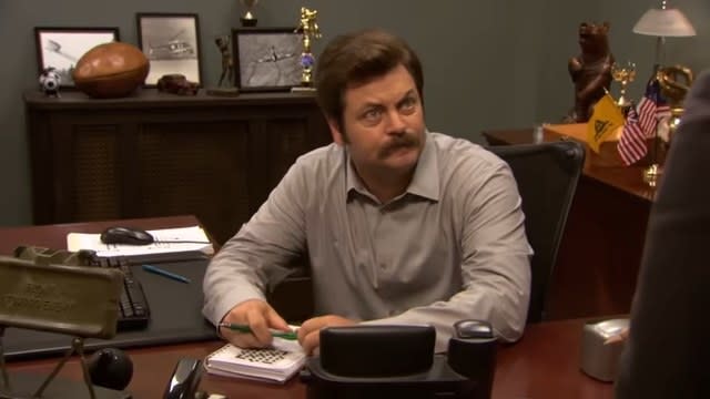 Ron at his desk talking to Leslie in "Parks and Recreation"