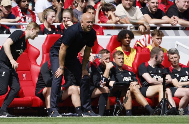 Liverpool head coach Arne Slot bends down with his hands on his knees on the touchline at Anfield.