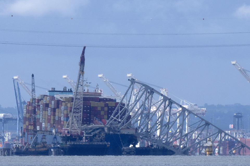 The collapsed Francis Scott Key Bridge rests on the container ship Dali, Sunday, May 12, 2024, in Baltimore, as seen from Riviera Beach, Md. An effort to remove sections of the collapsed bridge resting on the Dali was postponed on Sunday. (AP Photo/Mark Schiefelbein)