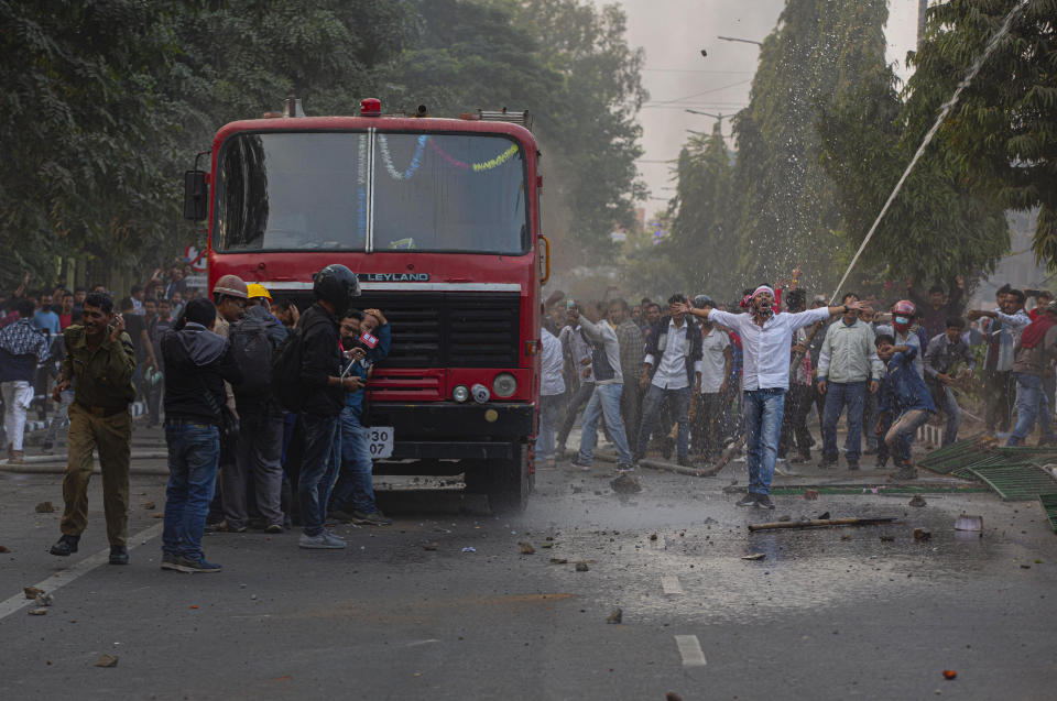 Protesters shout slogans against the Citizenship Amendment Bill (CAB) in Gauhati, India, Wednesday, Dec. 11, 2019. Protesters burned tires and blocked highways and rail tracks in India's remote northeast for a second day Wednesday as the upper house of Parliament began debating legislation that would grant citizenship to persecuted Hindus and other religious minorities from Pakistan, Bangladesh and Afghanistan. (AP Photo/Anupam Nath)