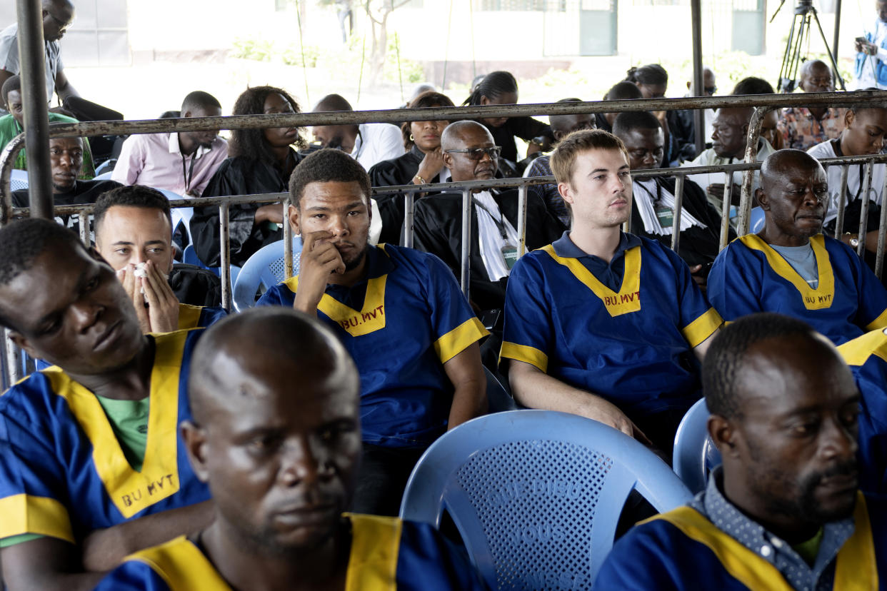 CORRECTS ID: Along the back row shows from left; Benjamin Reuben Zalman-Polun, Marcel Malanga and Tyler Thompson, all American citizens, attend a court verdict in Congo, Kinshasa, Friday, Sept. 13, 2024, on charges of taking part in a coup attempt in May 2024. (AP Photo/Samy Ntumba Shambuyi)