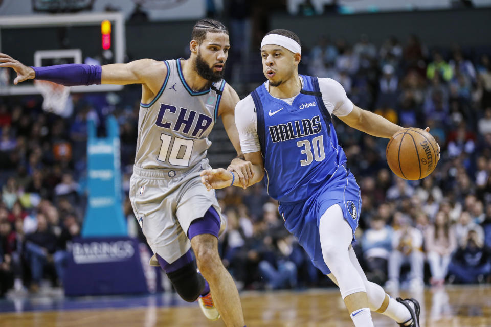 Dallas Mavericks guard Seth Curry, right, drives past Charlotte Hornets forward Caleb Martin during the second half of an NBA basketball game in Charlotte, N.C., Saturday, Feb. 8, 2020. Dallas won 116-100. (AP Photo/Nell Redmond)