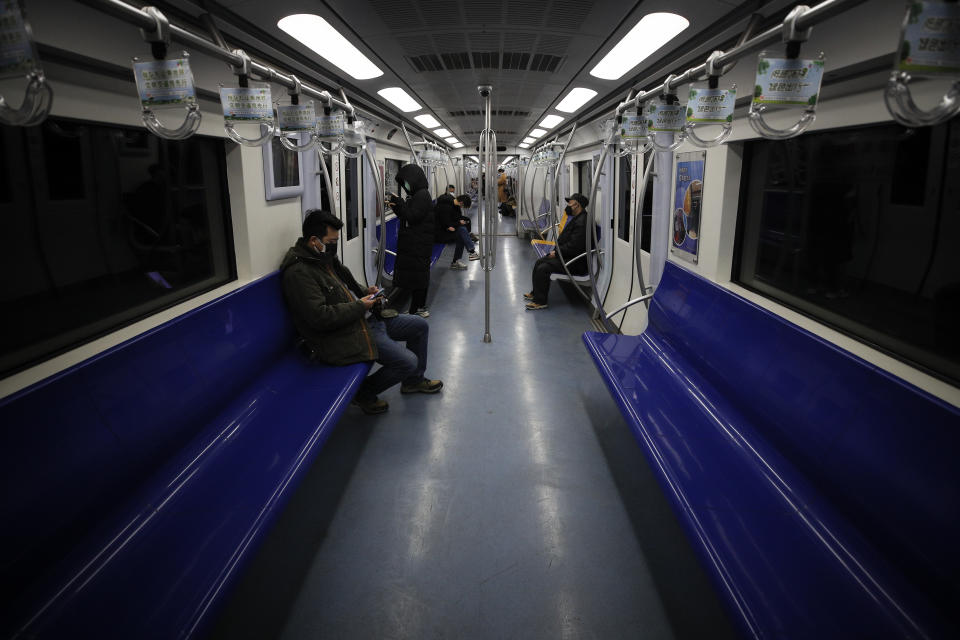 Commuters ride in a quiet subway train during the morning rush hour in Beijing, Monday, Feb. 17, 2020. Chinese authorities on Monday reported a slight upturn in new virus cases and hundred more deaths for a total of thousands since the outbreak began two months ago. (AP Photo/Andy Wong)