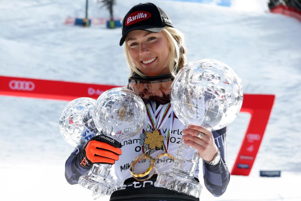 United States' Mikaela Shiffrin poses with her trophies for the alpine ski, World Cup slalom discipline, giant slalom discipline, and overall leader, right, in Soldeu, Andorra, Sunday, March 19, 2023. 