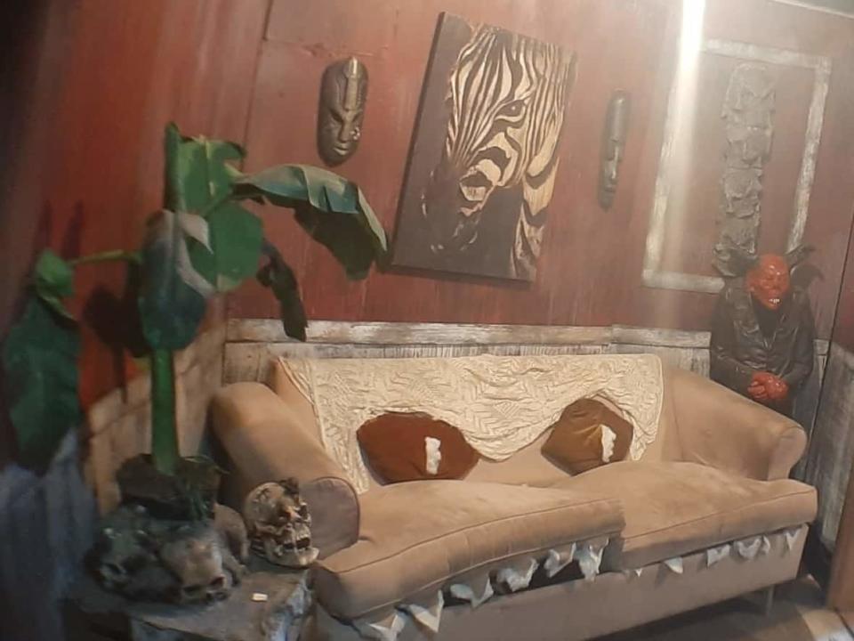 This people-eating couch is actually a giant puppet manoeuvred by someone situated safely behind the wall. Pat O'Neill found the couch as a free giveaway on Facebook and turned it into the focal point of a room in a Calgary haunt. (Submitted by Pat O'Neill - image credit)