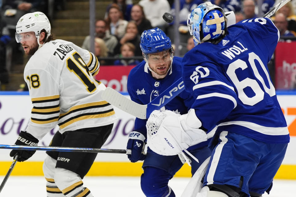 Toronto Maple Leafs goaltender Joseph Woll (60) makes a save as Boston Bruins center Pavel Zacha and Maple Leafs center Max Domi looks towards the puck during the first period of an NHL hockey game in Toronto on Monday, March 4, 2024. (Frank Gunn/The Canadian Press via AP)