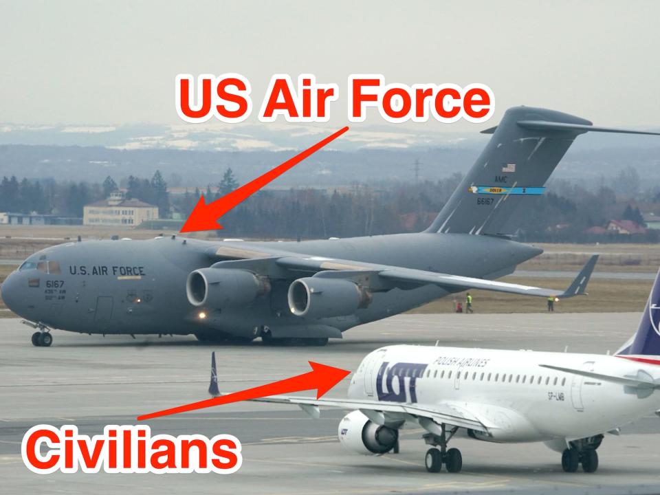 A US military plane and a LOT Polish Airlines civilian plane side by side