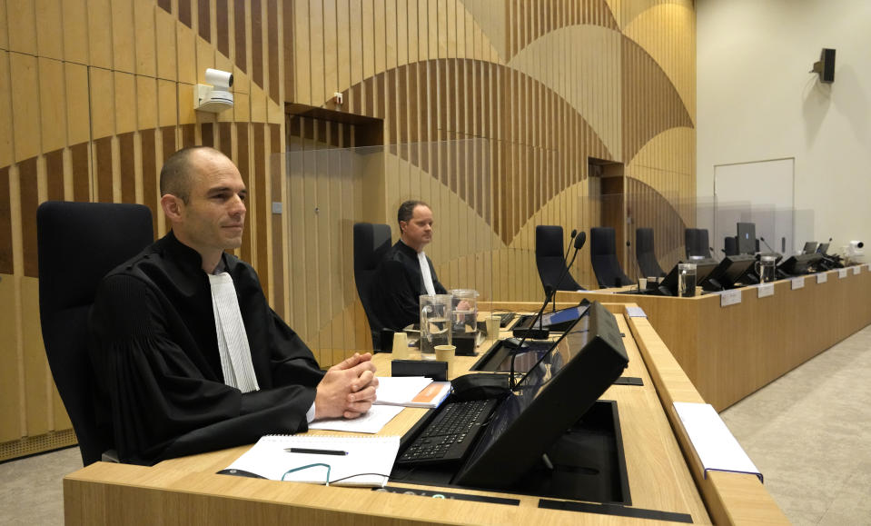 Public prosecutors Ward Ferdinandusse, left, and Thijs Berger wait for the start of the ongoing trial and criminal proceedings regarding the downing of Malaysia Airlines flight MH17, at the high security court at Schiphol airport, near Amsterdam, Netherlands, Monday Dec. 20, 2021. Prosecutors are scheduled to begin explaining evidence and their case to judges Monday in the murder trial of three Russians and a Ukrainian charged with involvement in downing Malaysia Airlines flight MH17 over eastern Ukraine in 2014, killing all 298 passengers and crew. (AP Photo/Peter Dejong)