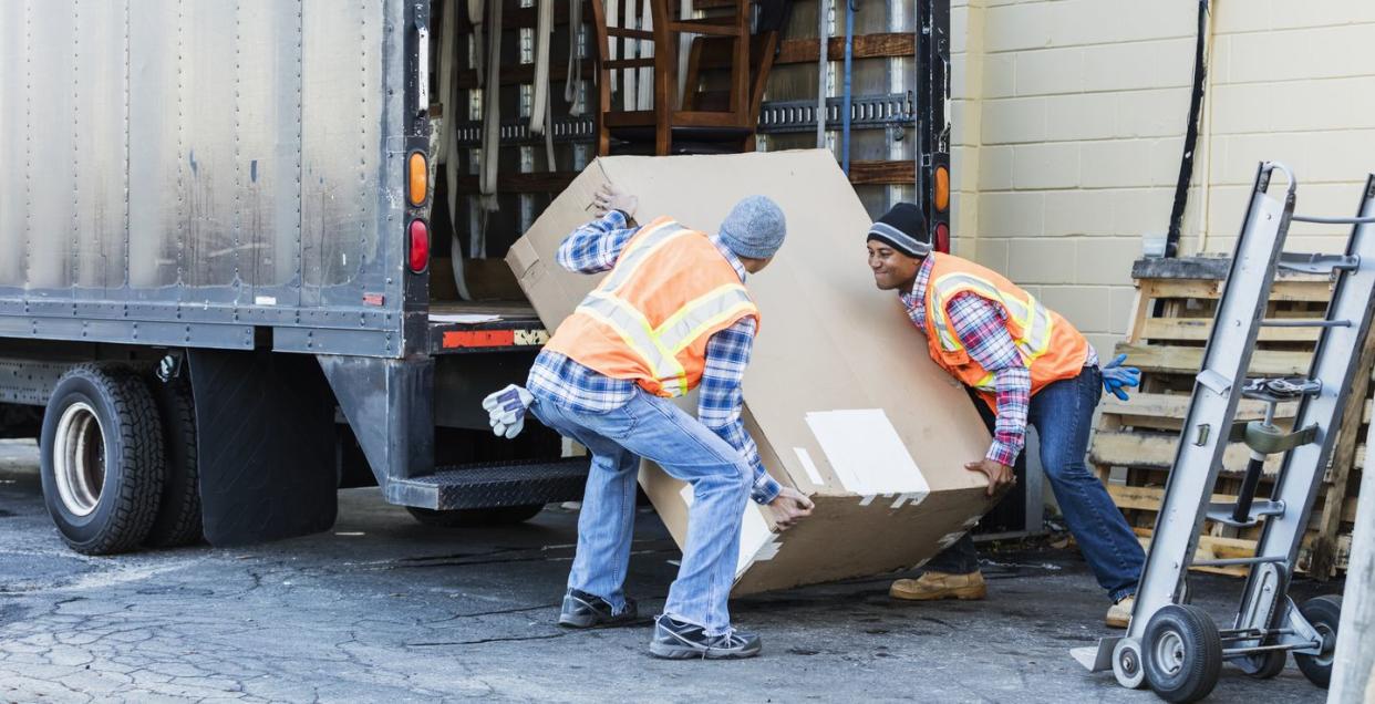 two workers with a truck, moving large box