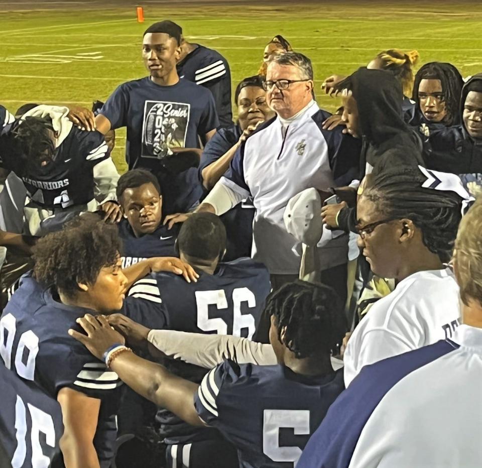 Coach JB Arnold talks to his Warrior football team on the field after their final home game of the 2022 season.