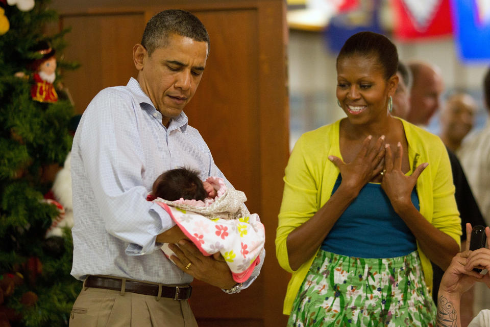 President Barack Obama holds one-month-old Adeline Valentina Hernandez Whitney as first lady Michelle Obama looks on, December 25, 2011 in Kaneohe, Hawaii. (Kent Nishimura-Pool/Getty Images)