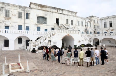 Foreign tourists listen to a guide at the Cape Coast Slave Castle