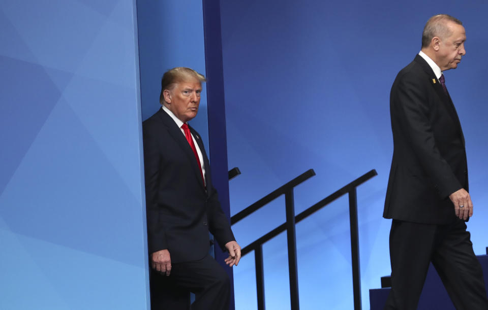 U.S. President Donald Trump, left, and Turkish President Recep Tayyip Erdogan step onto the stage to attend a ceremony event during a NATO leaders meeting at The Grove hotel and resort in Watford, Hertfordshire, England, Wednesday, Dec. 4, 2019. NATO Secretary-General Jens Stoltenberg rejected Wednesday French criticism that the military alliance is suffering from brain death, and insisted that the organization is adapting to modern challenges. (AP Photo/Francisco Seco)