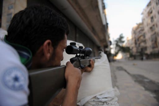 A fighter from the Syrian opposition aims fire during clashes with forces loyal to President Bashar al-Assad in Aleppo