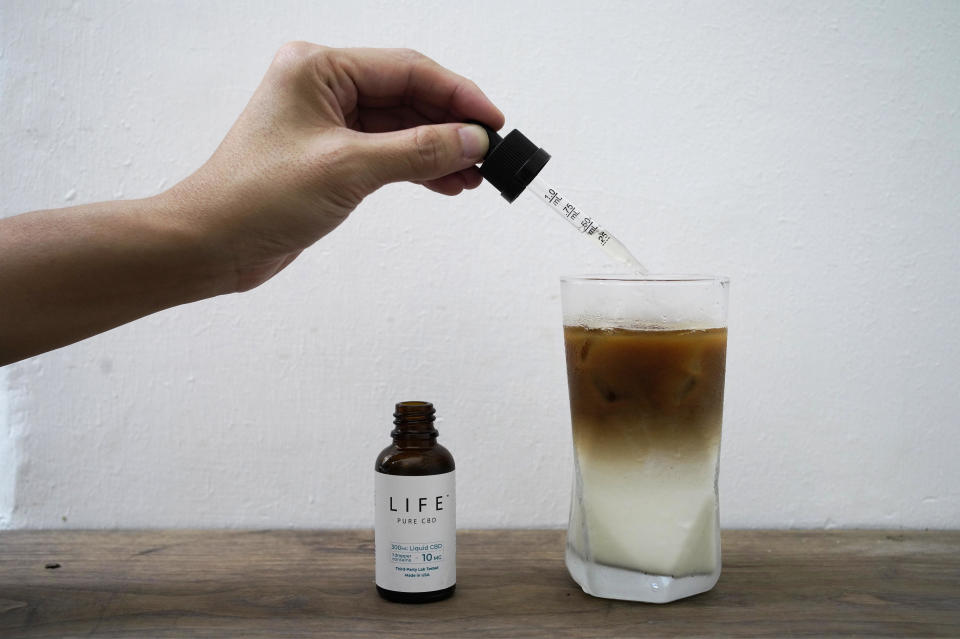 An employee adds drops of water-soluble CBD, or cannabidiol, to a glass of coffee at the Found café in Hong Kong, September 13, 2020. / Credit: Vincent Yu/AP