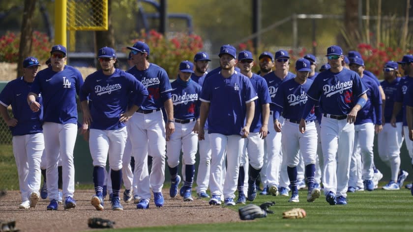 Los Angeles Dodgers players walk back to the infield after running sprints during a spring training baseball practice Tuesday, Feb. 23, 2021, in Phoenix. (AP Photo/Ross D. Franklin)