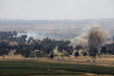 Smoke following an explosion is seen at Quneitra at the Syrian side of the Israeli Syrian border as it is seen from the Israeli-occupied Golan Heights, Israel July 22, 2018. REUTERS/Ronen Zvulun