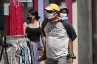 Shoppers walk by storefronts while wearing masks to protect against coronavirus, Saturday, July 25, 2020, in Bath, Maine. (AP Photo/Robert F. Bukaty)