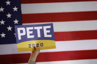 An attendee holds a campaign sign in front of an American flag as Democratic presidential candidate, former South Bend, Ind., Mayor Pete Buttigieg speaks during a campaign event, Wednesday, Jan. 15, 2020, in Newton, Iowa. (AP Photo/Patrick Semansky)