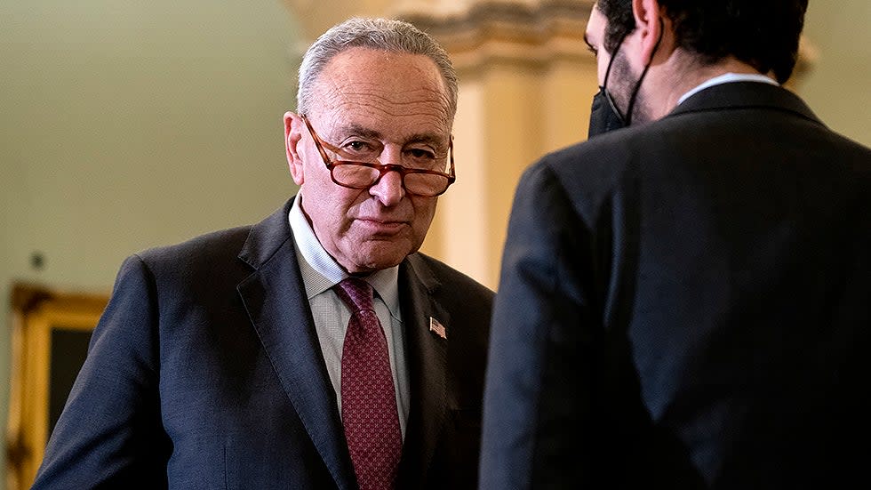 Majority Leader Charles Schumer (D-N.Y.) speaks to communication director Justin Goodman as Senate Democrats address reporters after the weekly policy luncheon on Tuesday, December 14, 2021.