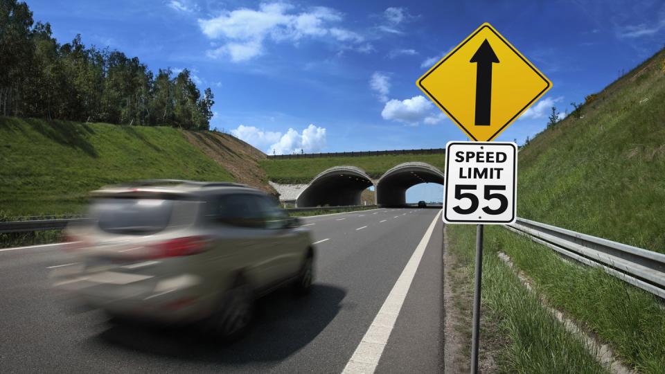 car going fast with speed limit road sign