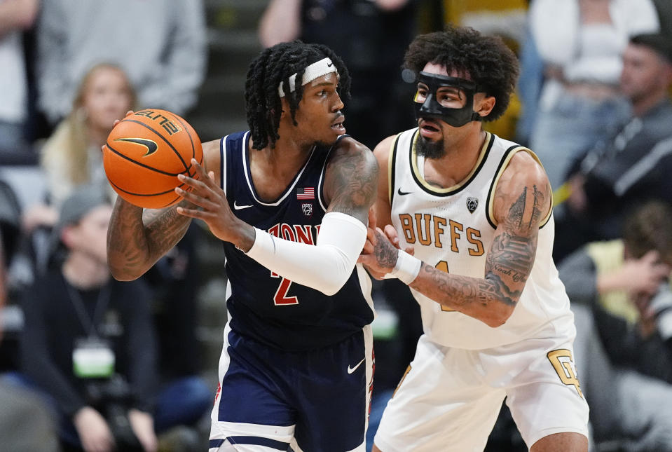 Arizona guard Caleb Love, left, looks to pass the ball as Colorado guard J'Vonne Hadley defends during the second half of an NCAA college basketball game Saturday, Feb. 10, 2024, in Boulder, Colo. (AP Photo/David Zalubowski)