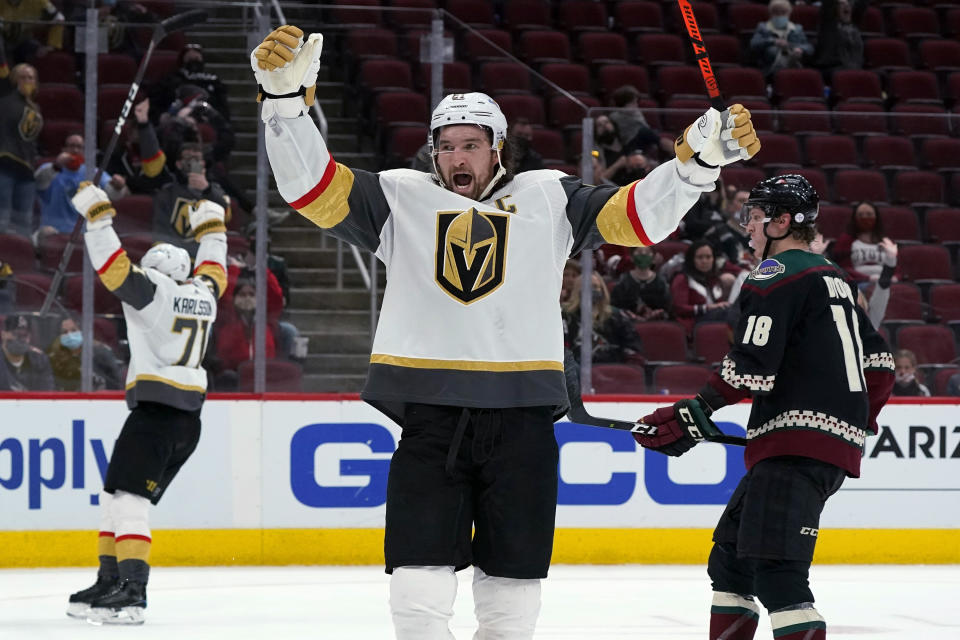 Vegas Golden Knights right wing Mark Stone, middle, and center William Karlsson (71) celebrate an overtime goal by Jonathan Marchessault, as Arizona Coyotes center Christian Dvorak (18) skates past, at an NHL hockey game Saturday, May 1, 2021, in Glendale, Ariz. The Golden Knights won 3-2. (AP Photo/Ross D. Franklin)