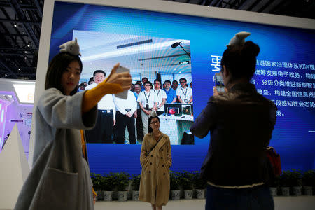 People pose for pictures during the third annual World Internet Conference in Wuzhen town of Jiaxing, Zhejiang province, China November 16, 2016. REUTERS/Aly Song/File Photo