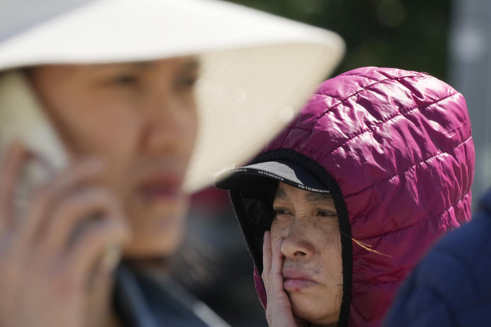 A woman wipes away a tear in Warsaw, Poland, Wednesday, May 15, 2024, outside a shopping center destroyed in a weekend fire. A weekend fire in a shopping center in Warsaw dealt tragedy to many members of Poland's Vietnamese community. People lost entire livelihoods and say they don't know how they will manage to make a living. (AP Photo/Czarek Sokolowski)