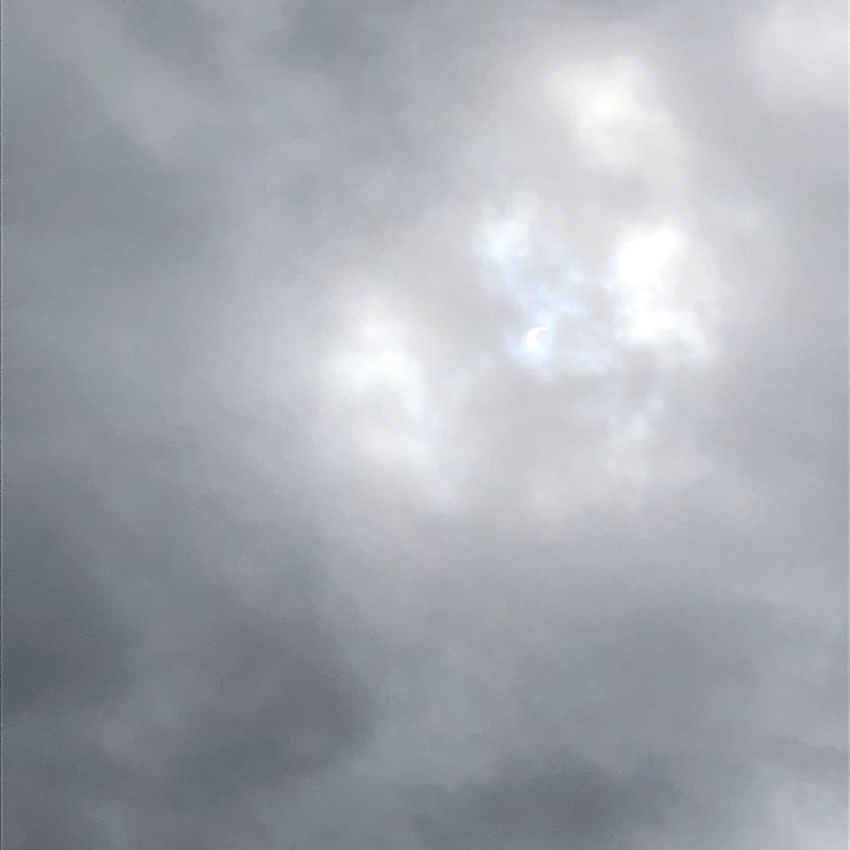 The view for most of the first hour of the solar eclipse in Staunton, Virginia was overcast. Occasionally, as in the center of this image, you could see the pale white horn of the sun behind the clouds.