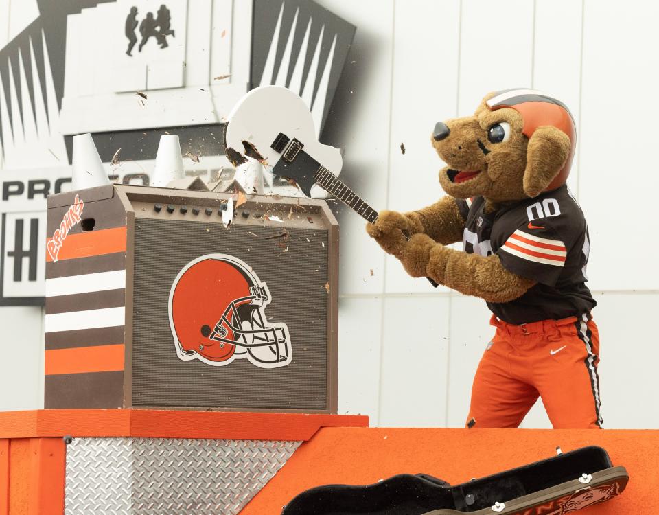 Cleveland Browns mascot Chomps smashes a guitar Friday on the steps of the Pro Football Hall of Fame to open its newest exhibit, "A Legacy Unleashed."