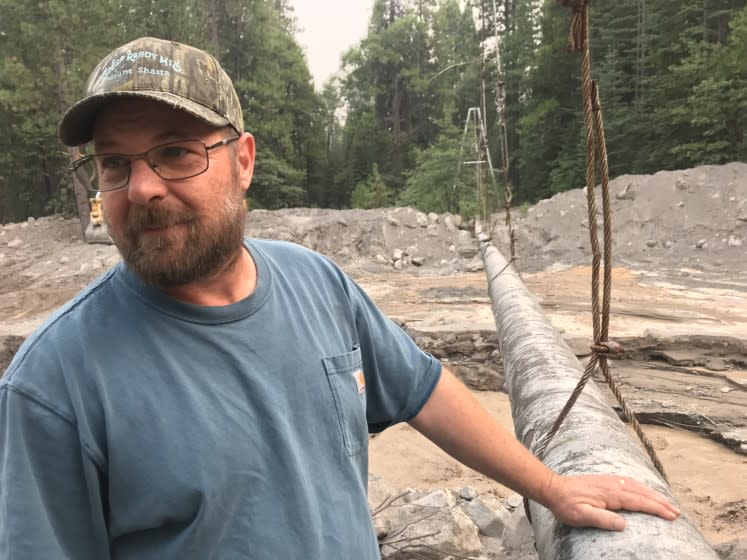 Richie Fesler, superintendent of public works for McCloud, a community of restored historic buildings on Shasta's southern flanks, is taking stock of progress being made in an effort to remove tens of thousands of cubic yards of mud that nearly buried a suspended pipeline that has supplied the area with spring water so pure it doesn't need chlorination since World War II.