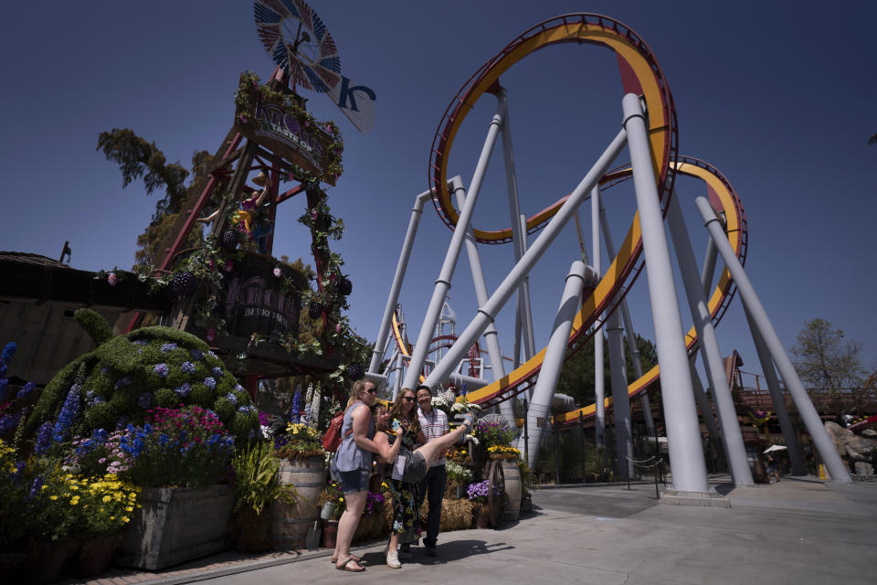 FILE - In this March 30, 2021 file photo, visitors pose for photos during the Knott's Taste of Boysenberry Festival at Knott's Berry Farm in Buena Park, Calif. California will allow indoor concerts, theater performances and other private gatherings starting April 15, 2021, as the rate of people testing positive for the coronavirus in the state nears a record low. (AP Photo/Jae C. Hong, File)