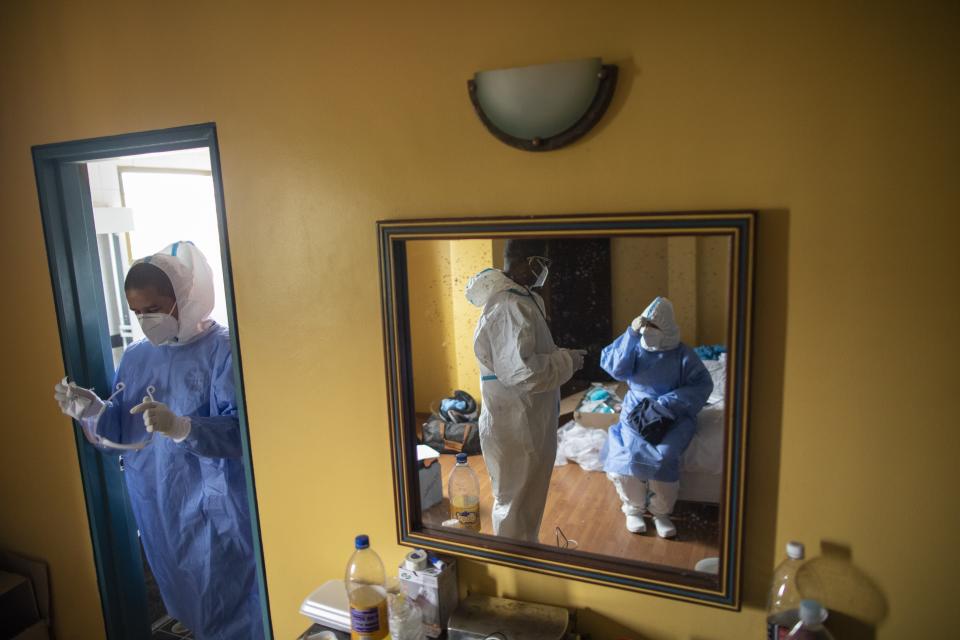 Venezuelan doctors speak in one of their rooms before going out to check on asymptomatic COVID-19 patients quarantining at a hotel in Caracas, Venezuela, Sunday, Aug 30, 2020. (AP Photo/Ariana Cubillos)