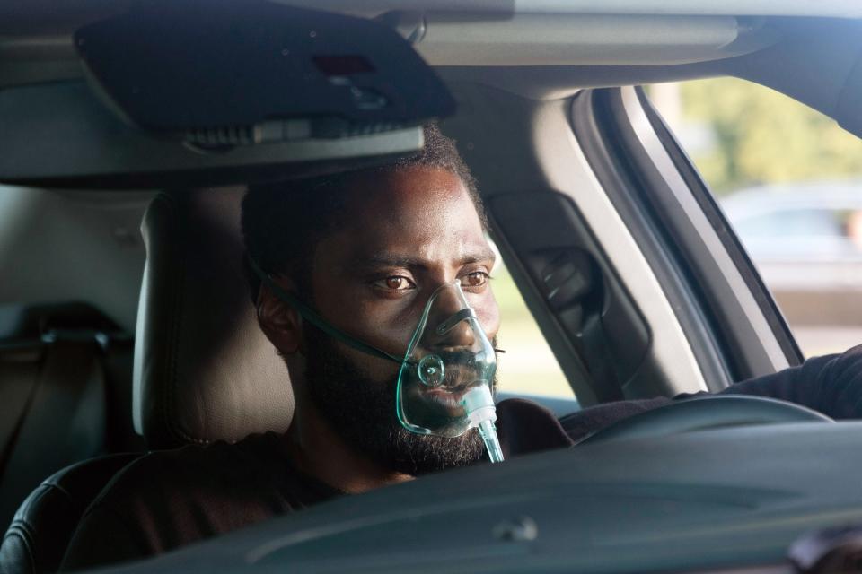 John David Washington wearing an oxygen mask in a car