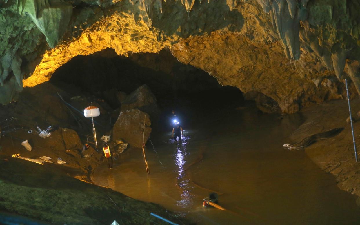 Rescuers walk out of the entrance to a cave complex where 12 football team members and their coach went missing, in Mae Sai, Chiang Rai province, in northern Thailand Saturday, June 30, 2018 - AP
