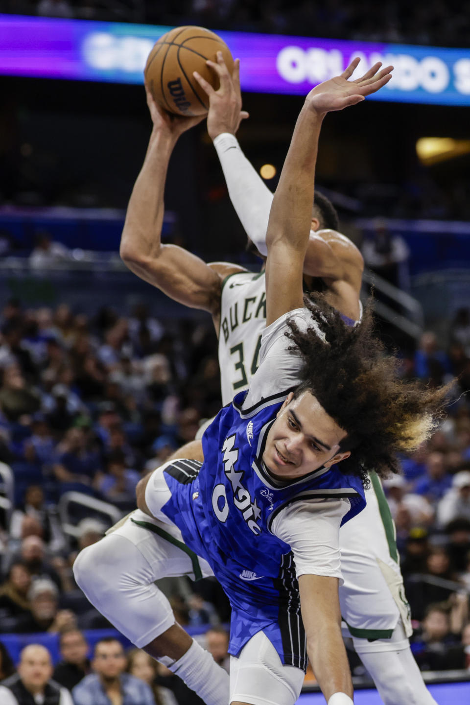 Orlando Magic guard Anthony Black, front, is fouled by Milwaukee Bucks forward Giannis Antetokounmpo during the second half of an NBA basketball game Saturday, Nov. 11, 2023, in Orlando, Fla. (AP Photo/Kevin Kolczynski)